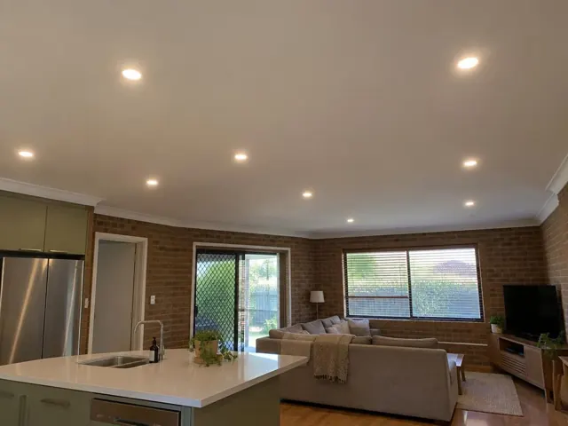 Open-plan living and kitchen room with recessed ceiling downlights in a brick home in Manly Vale